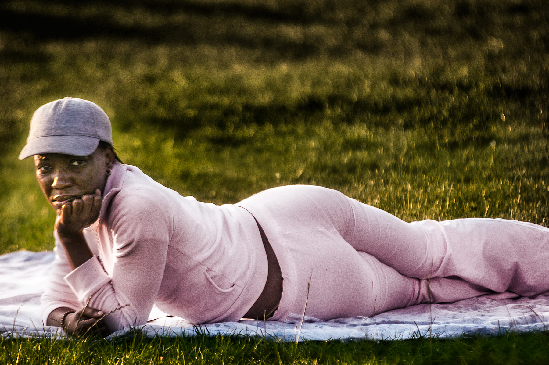 Black girl lying on grass on Clapham Common, London